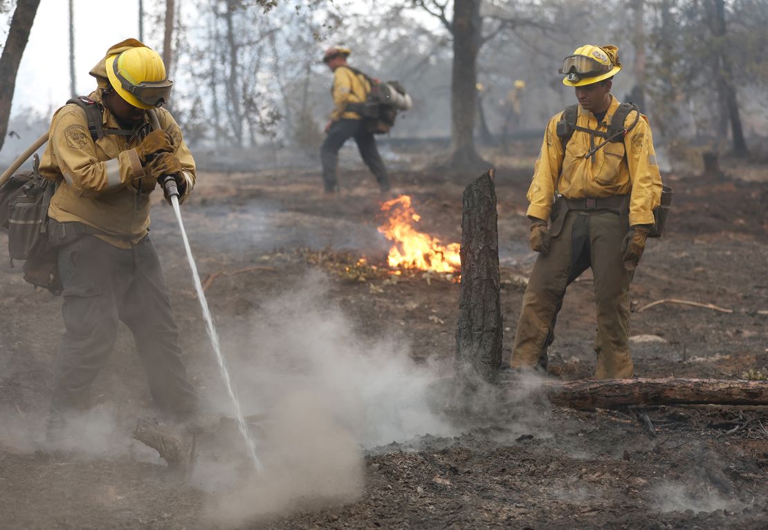 Firefighters work to contain hot spots from the Oak Fire, which began burning Friday.