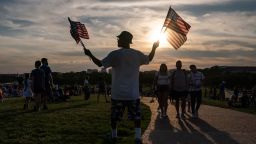 WASHINGTON, DC - JULY 04: A vendor sells American Flags to spectators waiting for the start of the Independence Day firework show at the Washington Monument on July 4, 2022 in Washington, DC. Crowds lined the National Mall to watch the capitals annual fireworks show celebrating the Fourth of July.