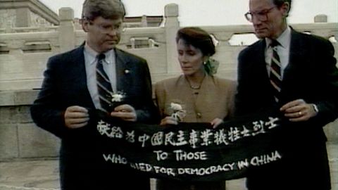 In this image taken from video, Pelosi and fellow US Reps. Ben Jones, left, and John Miller unfold a banner during a trip to Beijing in September 1991. The banner says, "To those who died for democracy in China."
