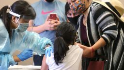 LAKEWOOD, CALIFORNIA - OCTOBER 14: A girl receives the flu vaccination shot from a nurse at a free clinic held at a local library on October 14, 2020 in Lakewood, California. Medical experts are hoping the flu shot this year will help prevent a 'twindemic'- an epidemic of influenza paired with a second wave of COVID-19 which could lead to overwhelmed hospitals amid the coronavirus pandemic. (Photo by Mario Tama/Getty Images)
