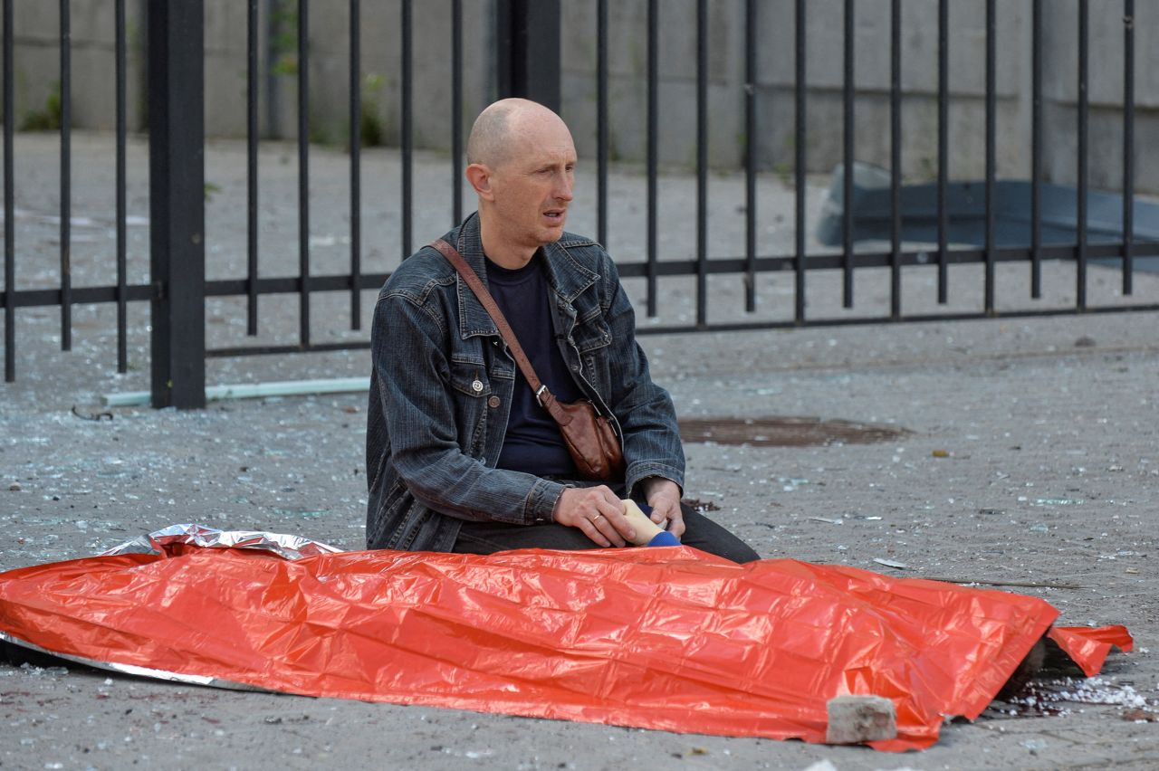 A man holds the hand of his 13 year-old son,  killed by a Russian military strike, in Kharkiv, Ukraine, on July 20.  