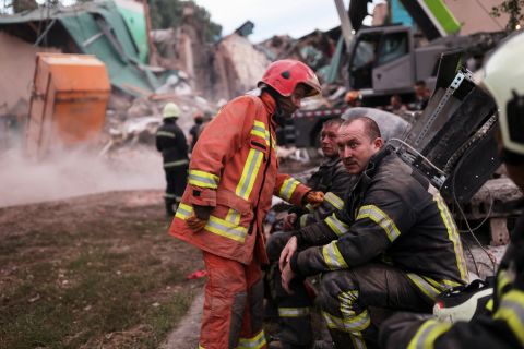 Firefighters rest as their colleagues remove debris during the search for bodies at the Central House of Culture, in Chuhuiv, Ukraine, after an air strike on July 25.