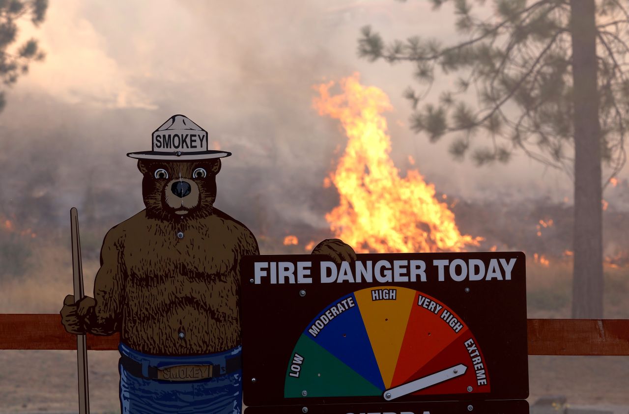 Fire burns near a Smokey the Bear warning sign on Sunday.