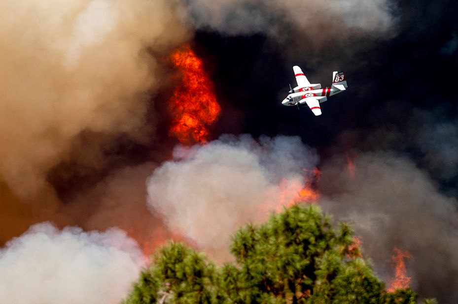 An air tanker flies past flames while battling the Oak Fire in Mariposa County on Sunday.