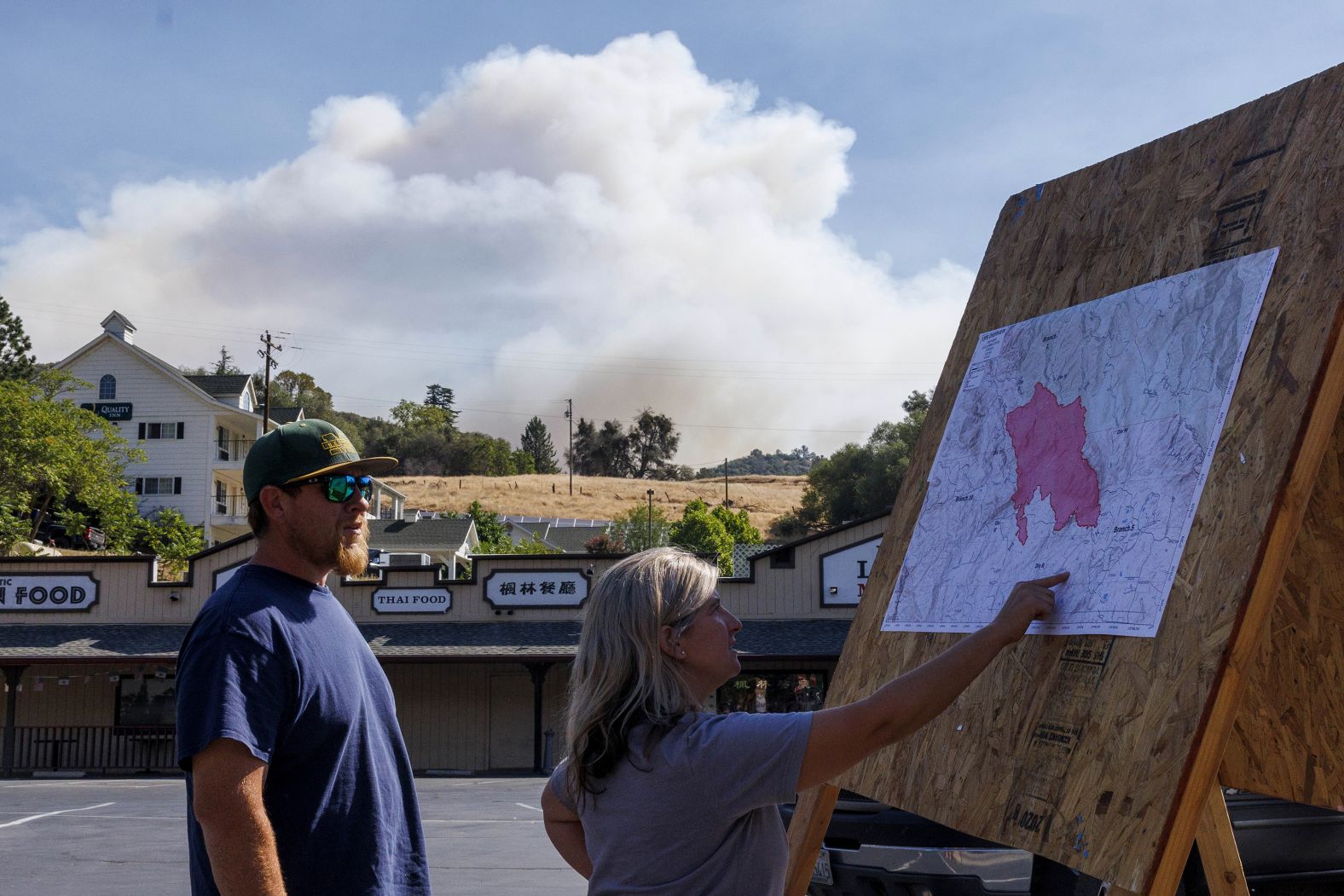 Local residents check a Cal Fire incident map in Mariposa on Saturday.