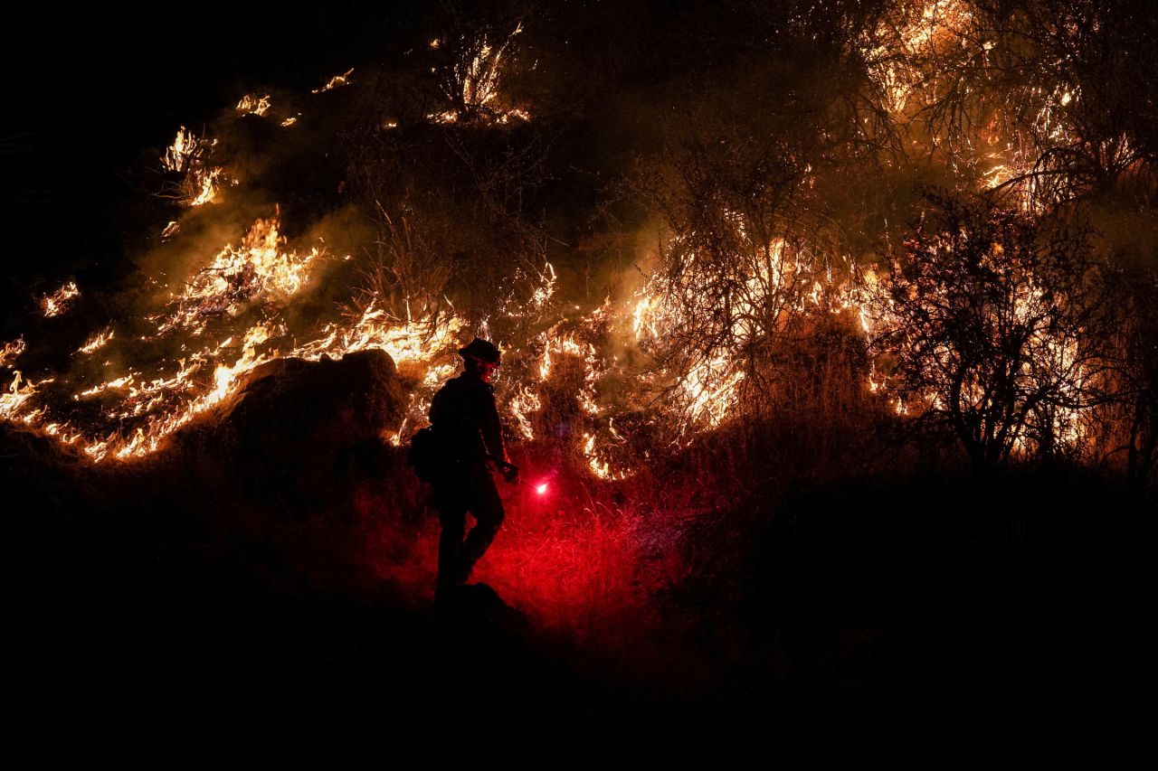 A firefighter lights a backburn near Mariposa on Friday.