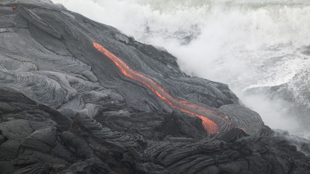 HAWAII - JUNE 6:  Lava flows into the ocean from Kilauea Volcano at Volcanoes National Park near Volcano, Hawaii June 6, 2004.  Lava from Kilauea has reached the ocean for the first time in nearly a year. (Photo by Marco Garcia/Getty Images)