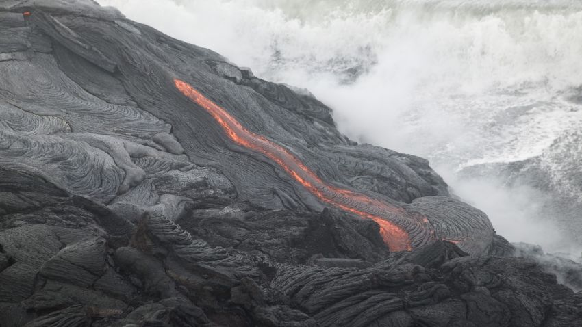HAWAII - 6 GIUGNO: La lava sfocia nel mare dal vulcano Kilauea nel vicino parco nazionale dei vulcani il 6 giugno 2004 alle Hawaii.  La lava del Kilauea è defluita nell'oceano per la prima volta in quasi un anno.  (Foto di Marco Garcia/Getty Images)