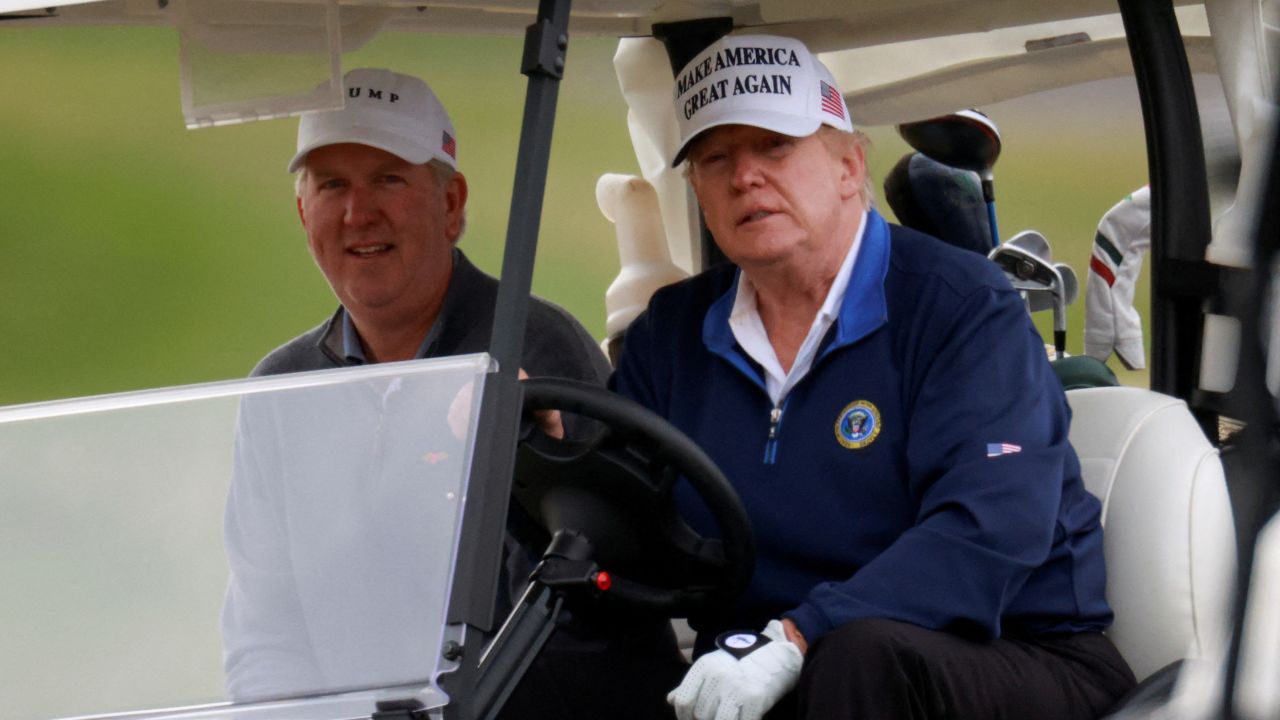 Trump drives a golf cart at the Trump National Golf Club in Sterling, Virginia.