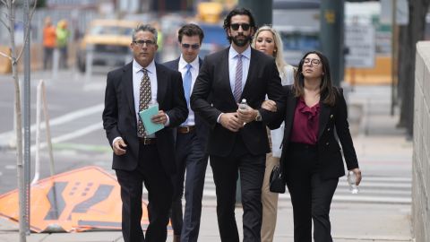 Lawrence Rudolph's defense investigator, left, heads into federal court in Denver along with the dentist's children.