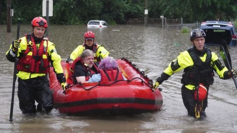 St. Louis firefighters seen bringing homeowners to dry land following flooding on Tuesday, July 26, 2022.