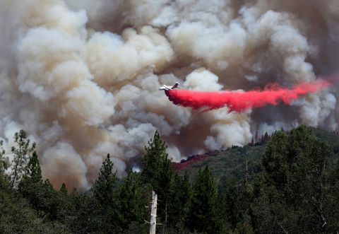 An airplane drops fire retardant ahead of the Oak Fire near Jerseydale, California, on Sunday, July 24.