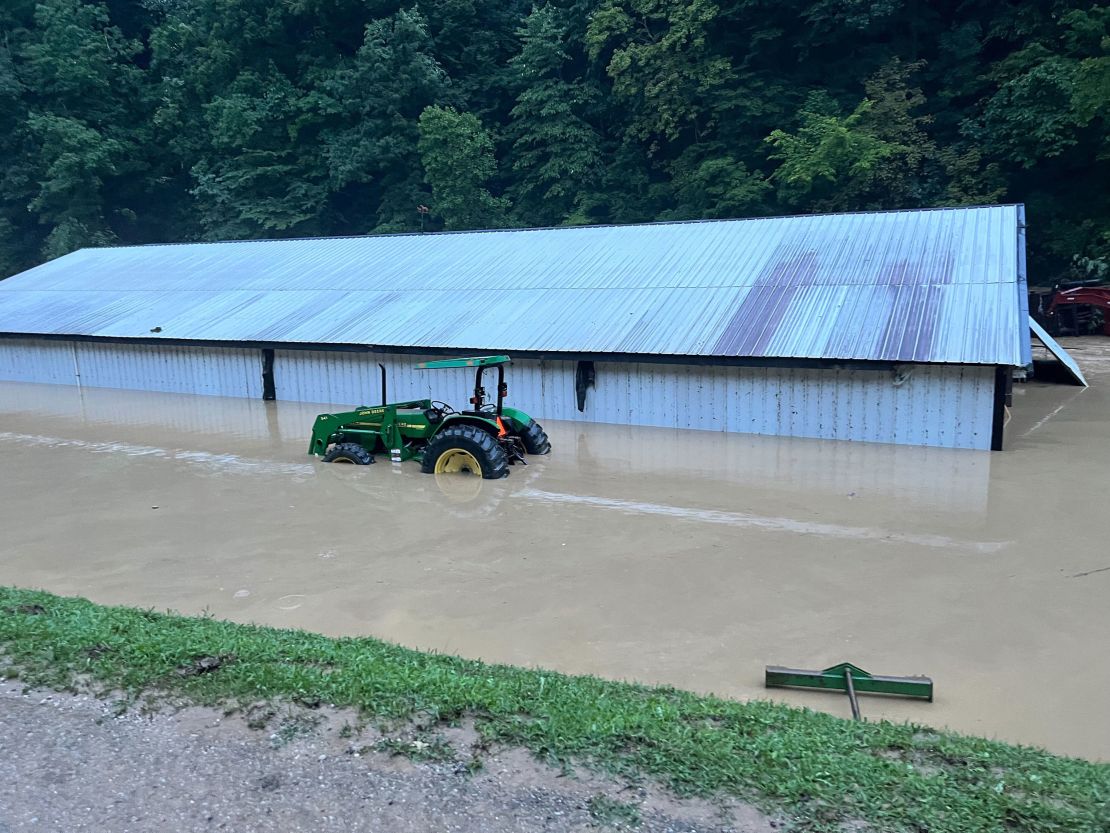 A barn is seen submerged in floodwaters. Behind it was where Asher's home, now wiped away, used to be.