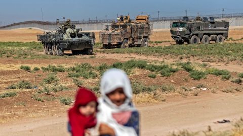 Syrian children stand near military vehicles during a joint Russian-Turkish patrol in the countryside, near the border with Turkey in Syria's northeastern Hasakah province on July 28.