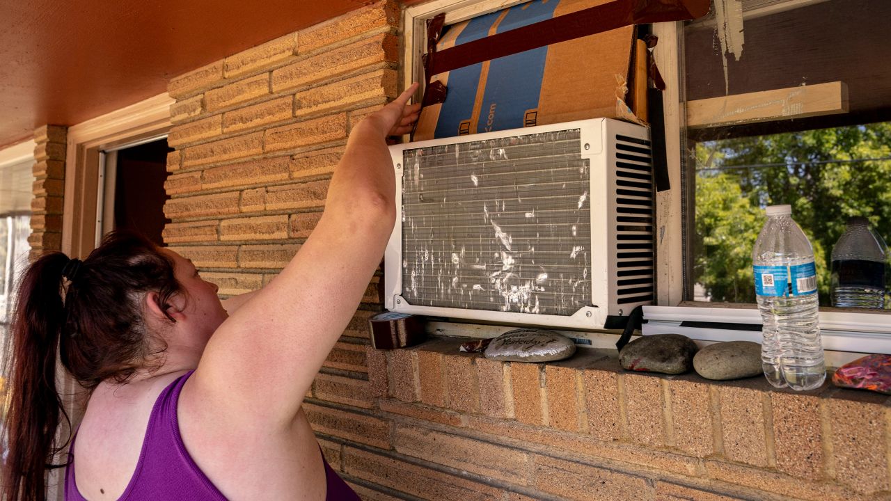 Kirstie Allemand arranges cardboard above an air conditioning unit in her window during soaring temperatures in Ellensburg, Washington. 