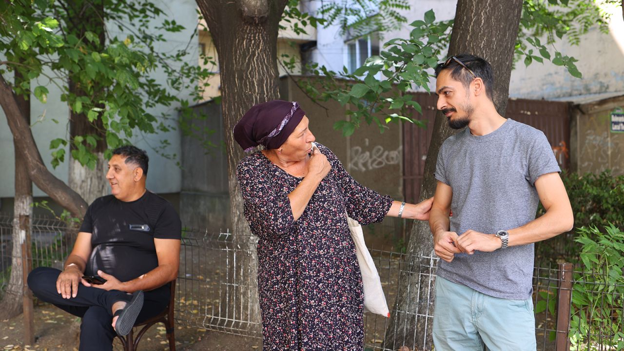 Nicu Dumitru speaks to a resident at one of the shelters housing predominantly Roma refugees in Bucharest on Saturday, July 16.