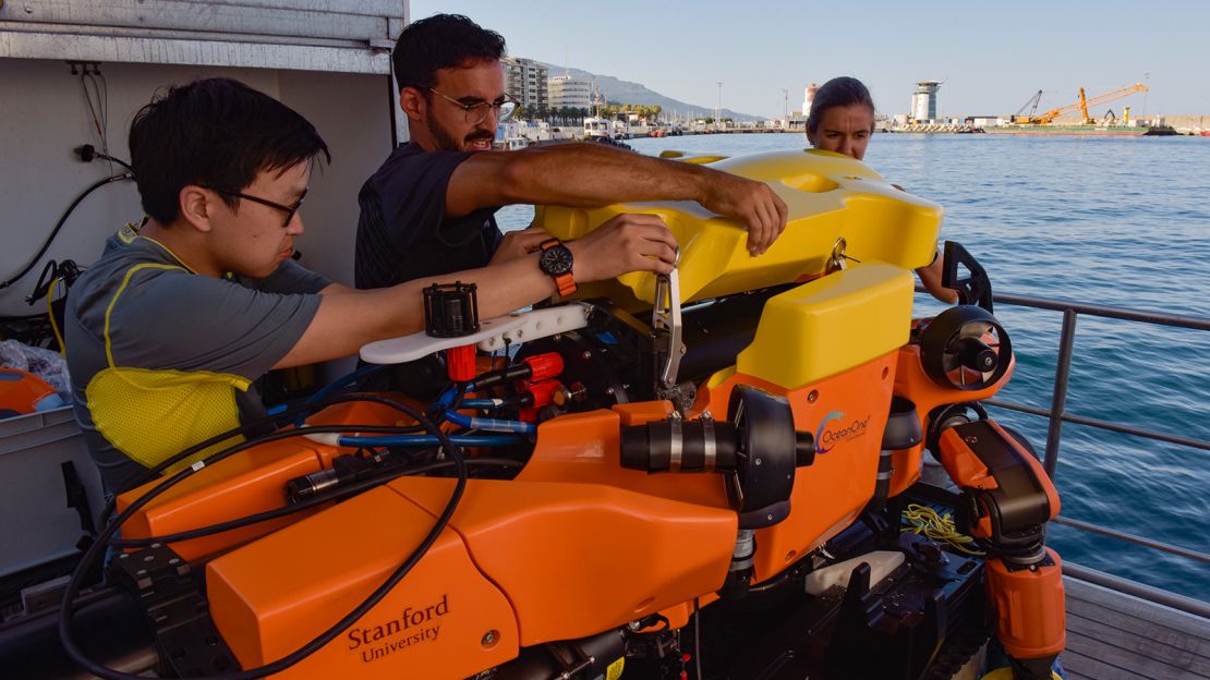 Students work to fix an issue with OceanOneK during an expedition.