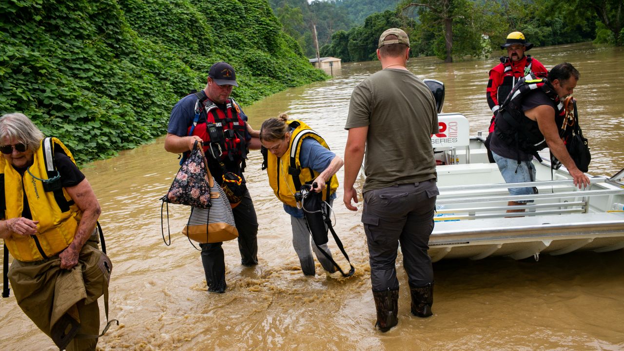 Members of a rescue team assist a family out of a boat on July 28, in Quicksand, Kentucky. 