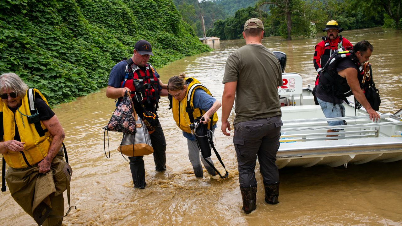 Members of a rescue team assist a family out of a boat on July 28, in Quicksand, Kentucky.
