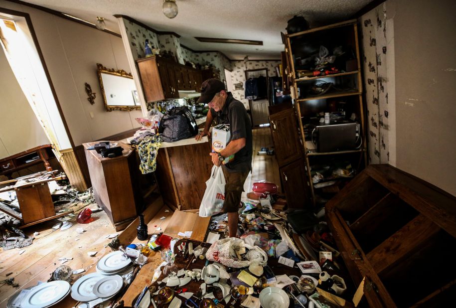 Kermit Clemons gathers personal items and medicine from the home of his former mother-in-law on Thursday. Flooding swept the trailer home off its foundation and carried it about 250 feet from its original location.