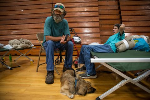Robert Hollan, Kimberly DiVietri and their dog, Rascal, wait in a shelter inside the Hazard Community College Lee's College campus on Thursday.