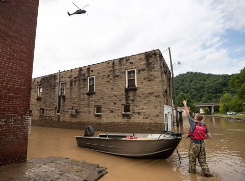 James Jacobs signals to a National Guard helicopter flying overhead in Garrett, Kentucky, on Thursday.