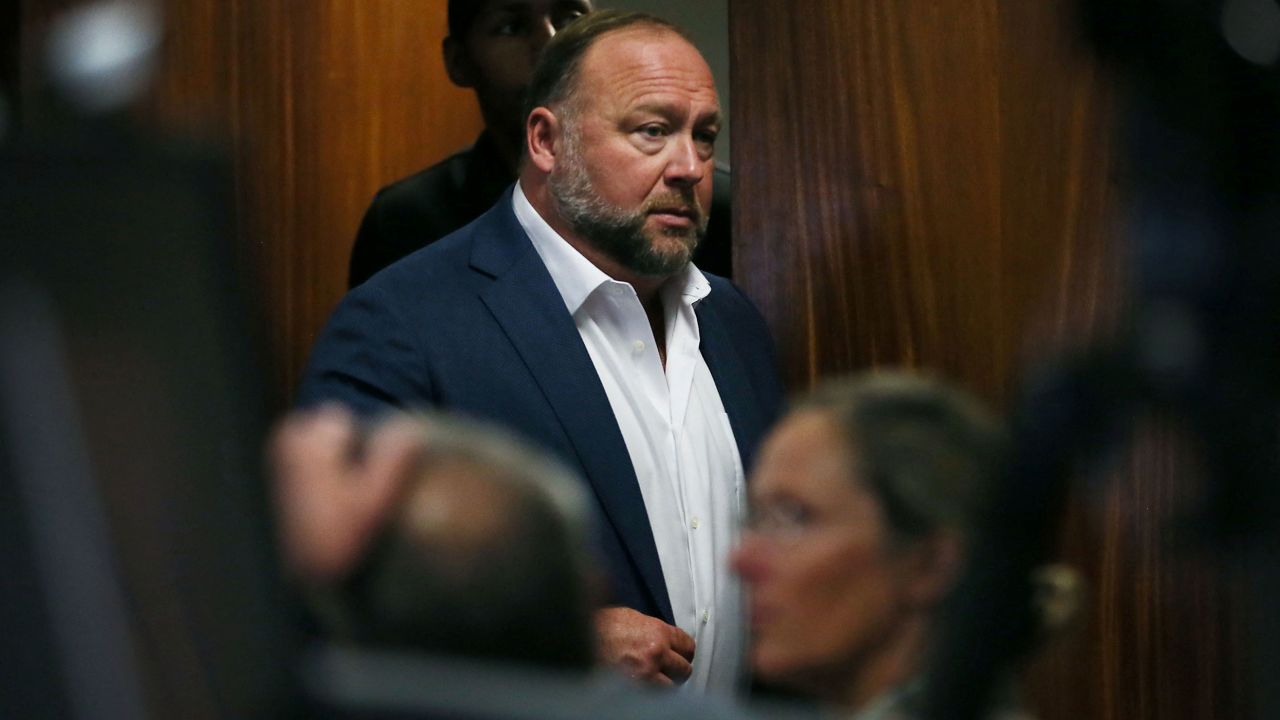 Alex Jones walks into the courtroom in front of Scarlett Lewis and Neil Heslin, the parents of 6-year-old Sand Hook shooting victim Jesse Lewis, at the Travis County Courthouse in Austin, Texas, U.S. July 28, 2022. Jones had been found to have defamed the parents of a Sandy Hook student for calling the attack a hoax, and the parents are seeking $150 million in compensatory and punitive damages for what they say was a campaign of harassment and death threats by Jones' followers.