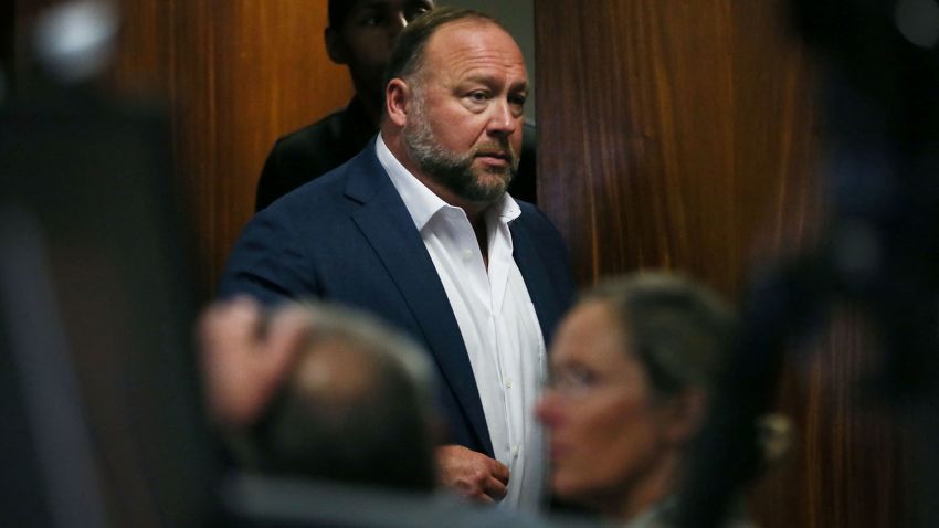 Alex Jones walks into the courtroom in front of Scarlett Lewis and Neil Heslin, the parents of 6-year-old Sand Hook shooting victim Jesse Lewis, at the Travis County Courthouse in Austin, Texas, U.S. July 28, 2022. Jones had been found to have defamed the parents of a Sandy Hook student for calling the attack a hoax, and the parents are seeking $150 million in compensatory and punitive damages for what they say was a campaign of harassment and death threats by Jones' followers.    