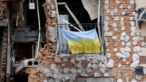  A Ukrainian national flag hangs from a balcony of a civilian destroyed buildings in Irpin, Ukraine, on June 16, 2022. 