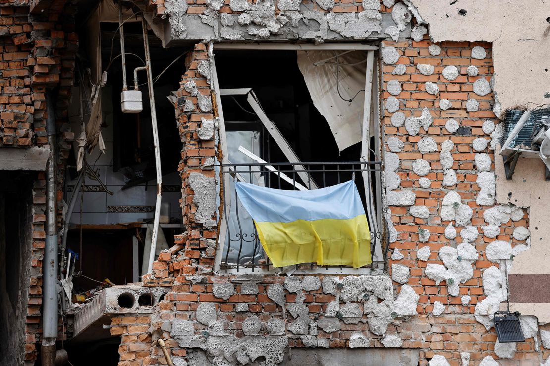  A Ukrainian national flag hangs from a balcony of a civilian destroyed buildings in Irpin, Ukraine, on June 16, 2022. 