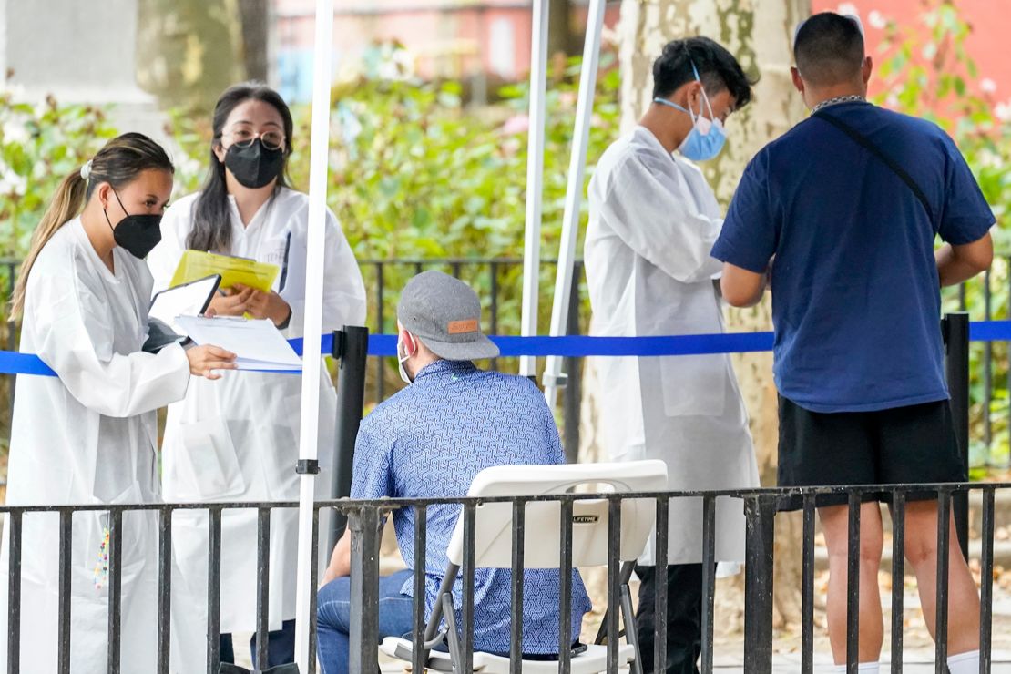 Healthcare workers with the New York City Department of Health and Mental Hygiene help people register for the monkeypox vaccine at a city vaccination site on July 26, 2022. 