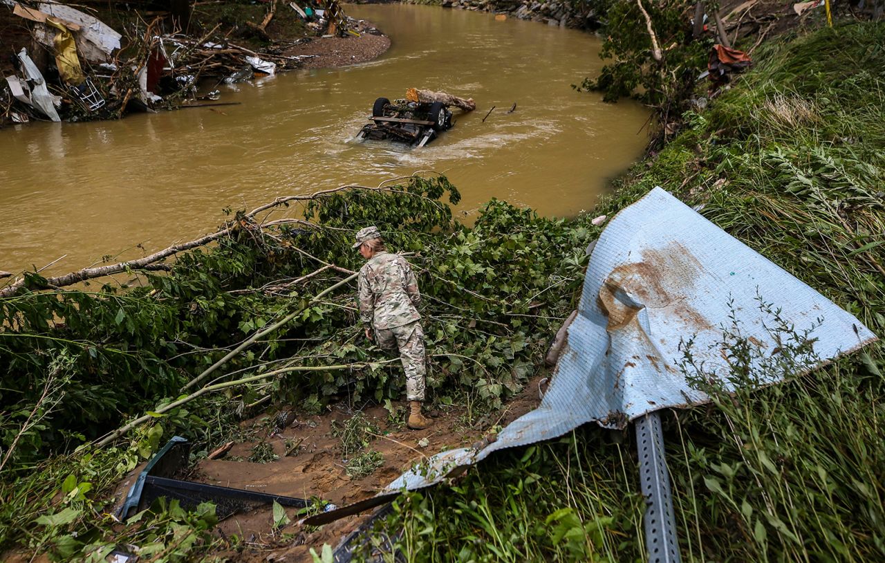 A member of the Kentucky National Guard looks for flood victims near a creek in Fisty, Kentucky, on Saturday. 