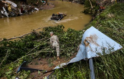 A Kentucky National Guard soldier looks through debris near Troublesome Creek for flood victims in Fisty, Kentucky on Saturday morning. 
