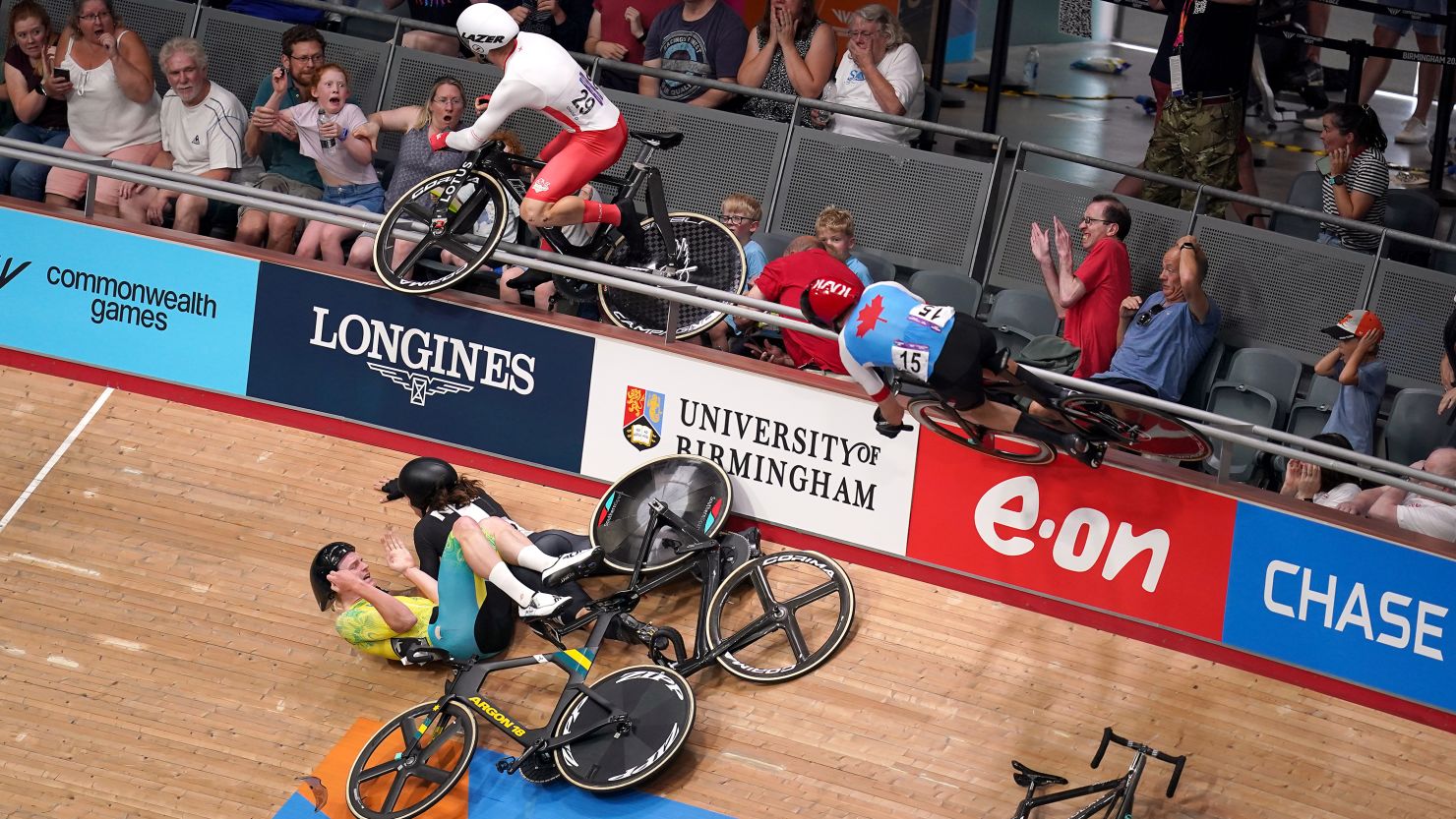 A crash in the Men's 15km scratch race qualifying round as England's Matt Walls (no.29) and Canada's Derek Gee (no.15) go over the barrier into the crowd in London on July 31, 2022.