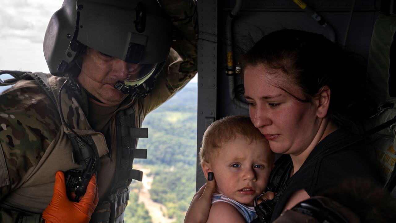 Command Sgt. Major Tim Lewis of the Kentucky National Guard secures Candace Spencer, 24, while she holds her son Wyatt, 1, after being airlifted on July 30, 2022, from South Fork, Breathitt County, Kentucky.