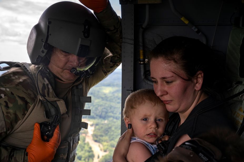 Command Sgt. Maj. Tim Lewis of the Kentucky National Guard secures Candace Spencer and her son Wyatt after being airlifted from South Fork, Kentucky, on Saturday.