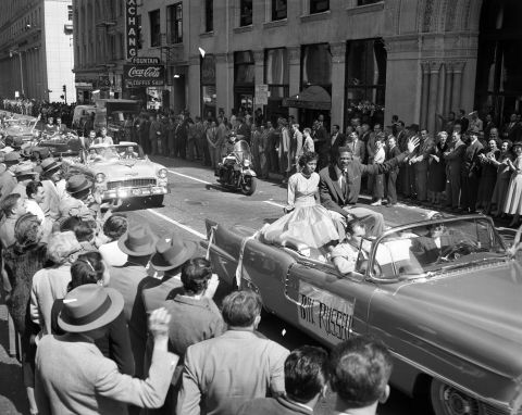 Russell and Rose Swisher wave to the crowd during a parade in San Francisco, California, on March 22, 1955, celebrating the USF Dons victory during the NCAA championship title.<br />