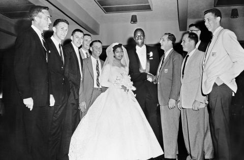 Russell and Swisher at their wedding in Oakland, California in 1956. The couple married after Russell won the gold medal at the Melbourne Olympics, surrounded by his coaches and teammates.