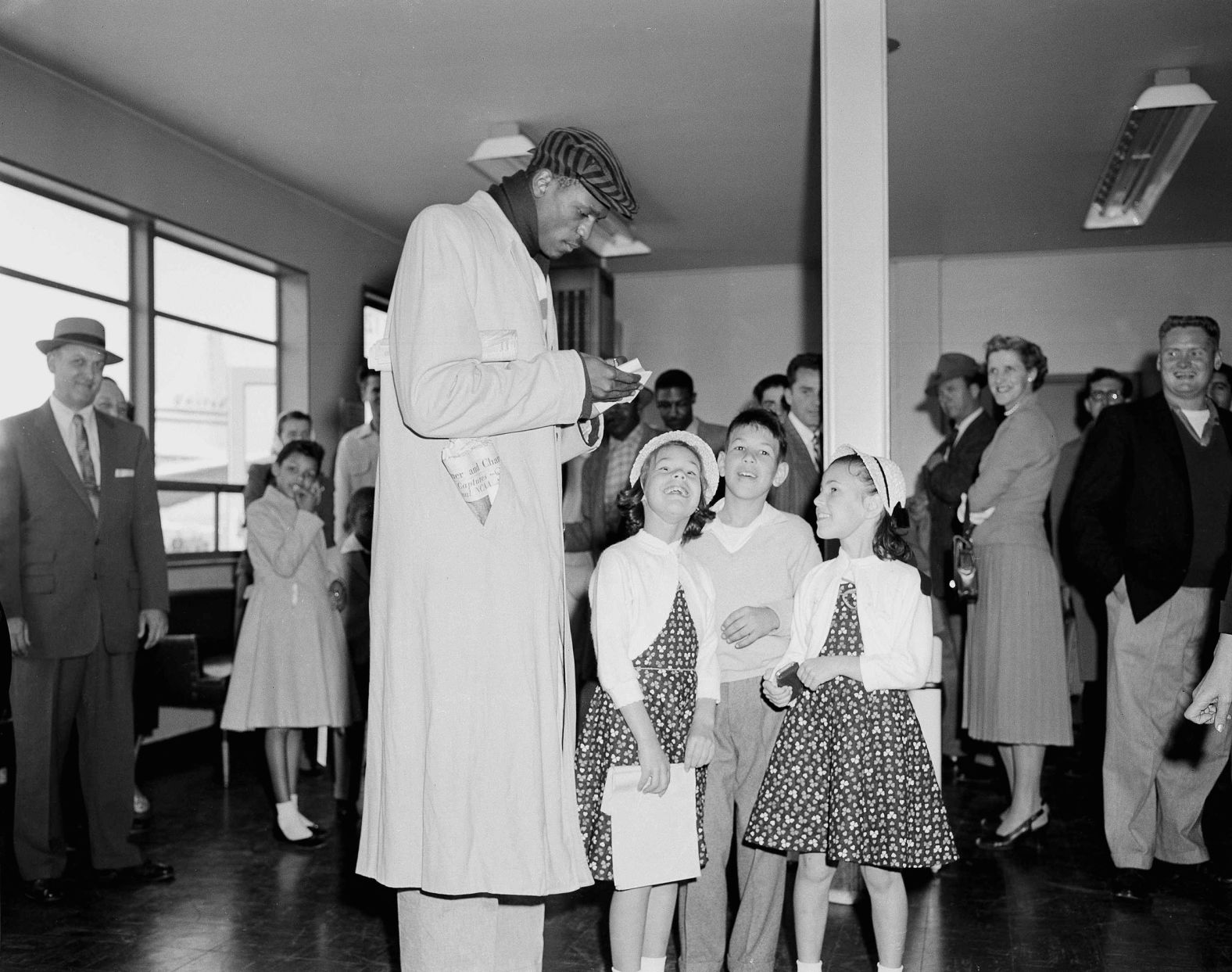 Russell signs autographs for young fans at San Francisco International Airport in March 1956.