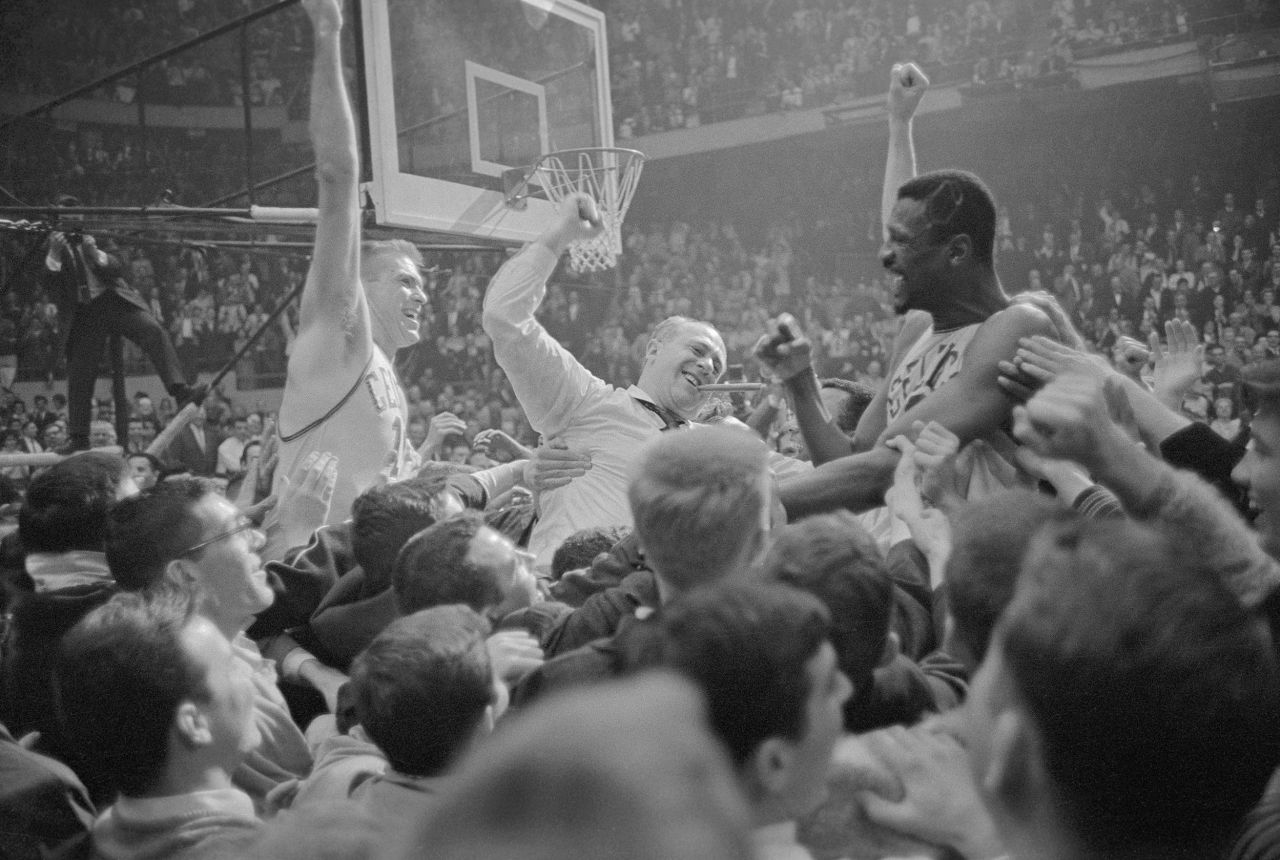 From left, fans carry then-Celtics forward Tommy Heinsohn, coach Red Auerbach and Russell around the court after Boston won their sixth consecutive NBA title in 1964.