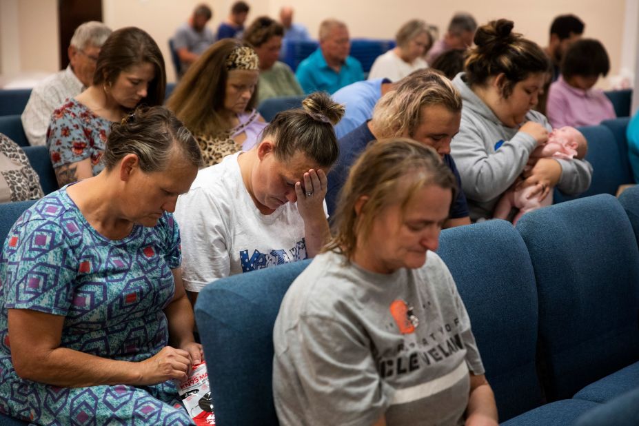 Karen Daugherty holds her head in her hands during a service at the Gospel Light Church in Hazard, Kentucky. Daugherty is staying with her family in the church, which has been set up as a shelter.