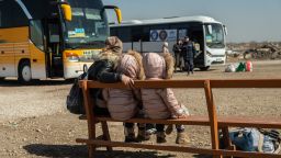 An Ukrainian mother and her daughters are seen waiting for the bus at the transit point for refugees in Palanca, south Moldova, on March 27, 2022.