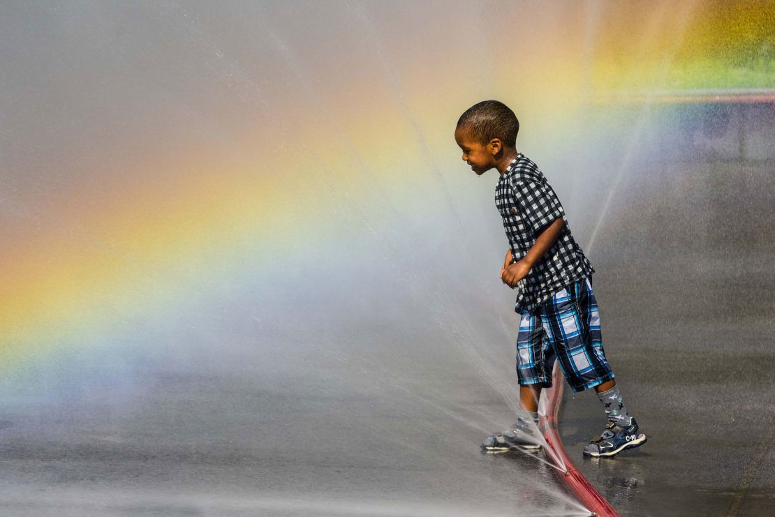 A child using a cooling down water feature on Schwarzenberg Square in Vienna, Austria.