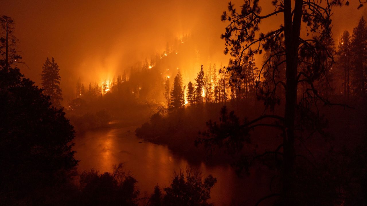 Flames burn to the Klamath River during the McKinney Fire in the Klamath National Forest northwest of Yreka, California, Sunday.