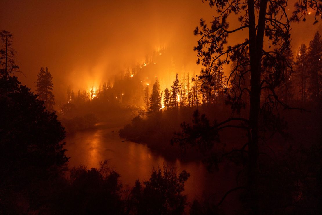 Flames burn to the Klamath River during the McKinney Fire in the Klamath National Forest northwest of Yreka, California, Sunday.