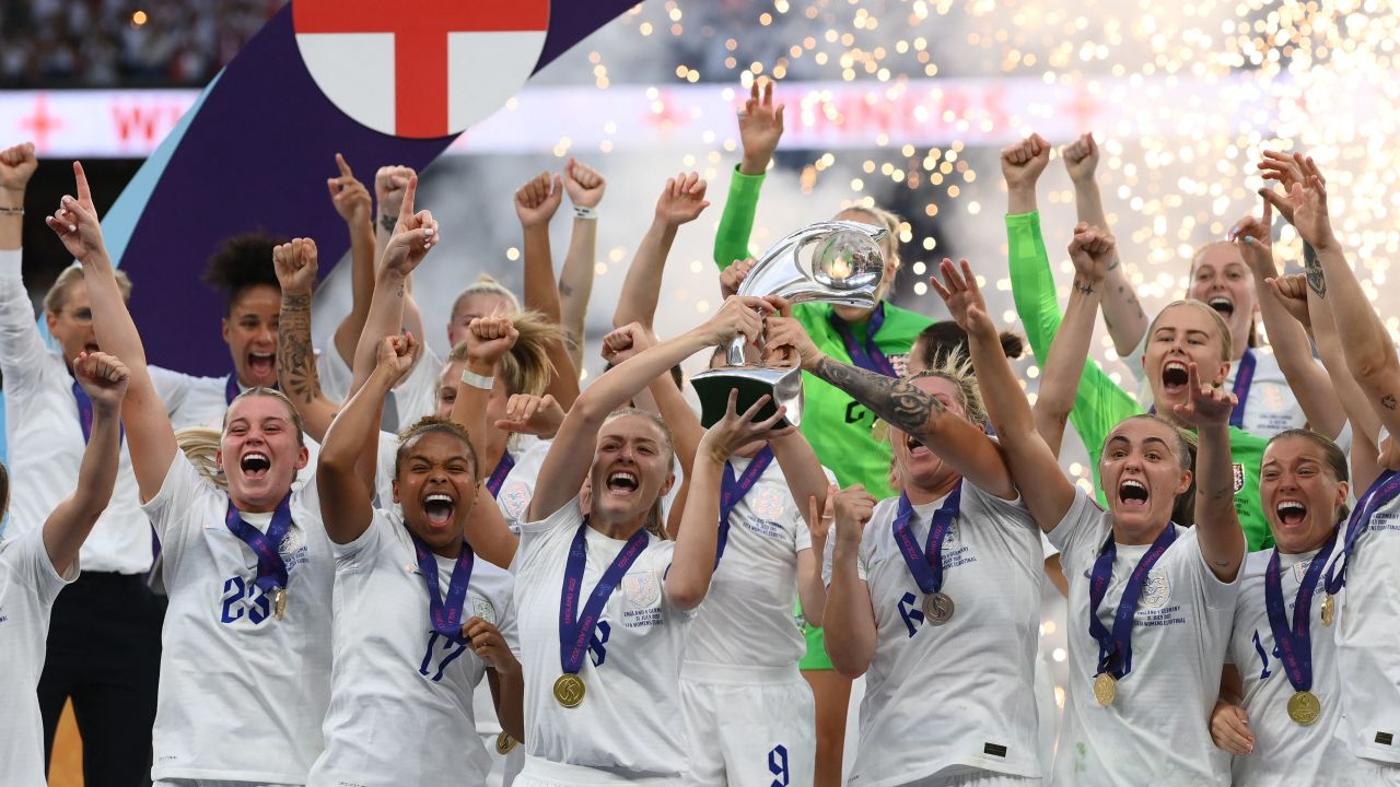 TOPSHOT - England's midfielder Leah Williamson (centre left) and England's defender Millie Bright (centre right) lift the trophy as England's players celebrate after their win in the UEFA Women's Euro 2022 final football match between England and Germany at the Wembley stadium, in London, on July 31, 2022. - England won a major women's tournament for the first time as Chloe Kelly's extra-time goal secured a 2-1 victory over Germany at a sold out Wembley on Sunday. - No use as moving pictures or quasi-video streaming. 
Photos must therefore be posted with an interval of at least 20 seconds. (Photo by FRANCK FIFE / AFP) / No use as moving pictures or quasi-video streaming. 
Photos must therefore be posted with an interval of at least 20 seconds. (Photo by FRANCK FIFE/AFP via Getty Images)
