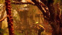 A firefighter battling the McKinney Fire protects a cabin in Klamath National Forest, Calif., on Sunday, July 31, 2022. (AP Photo/Noah Berger)