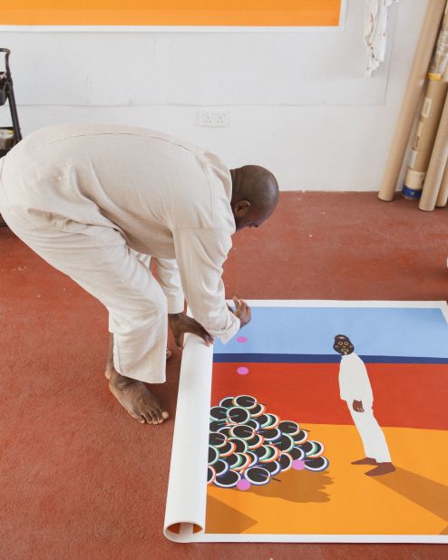 Osadebe, pictured here unrolling one of his self-portraits in his studio in Nigeria, says art is about developing a visual language that transcends geographic boundaries.