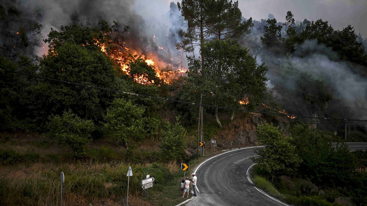 Villagers watch the progression of a wildfire at Eiriz in Baiao, north of Portugal, on July 15, 2022.