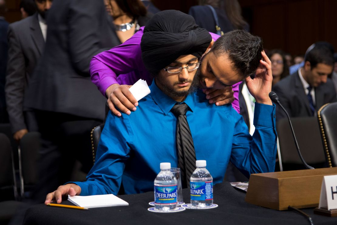 Harpreet Singh Saini, left, gets a hug from his brother Kamal, before testifying during a September 2012 hearing on Capitol Hill. Their mother, Paramjit Kaur, was killed about a month earlier.